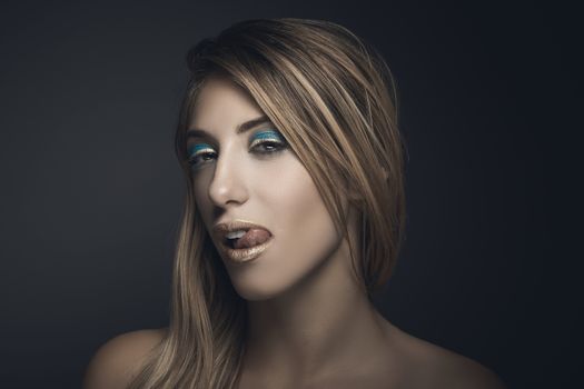 Beauty portrait of sexy blonde woman against grey background