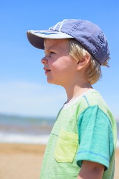 Closeup portrait of little boy on the sandy beach