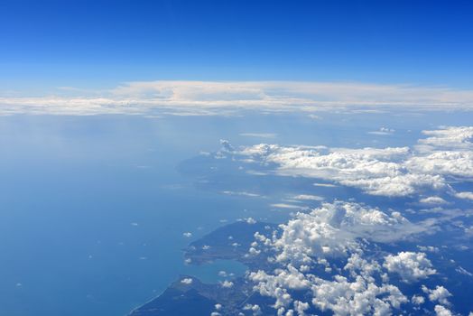 Earth's surface with sea and clouds. Top view of aircraft