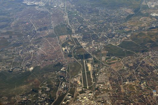 Aerial view of the city. Buildings, fields, trees and roads