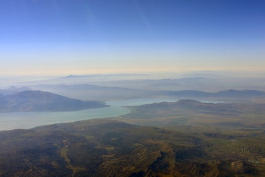 View from the plane on mountain, river and sky