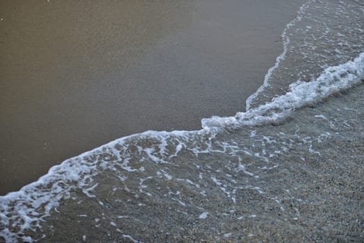 Seawater on the sandy beach. Natural background