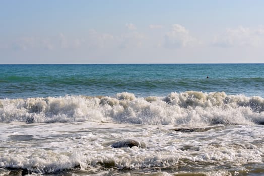 Sea wave rolled ashore. Blue sky in the background