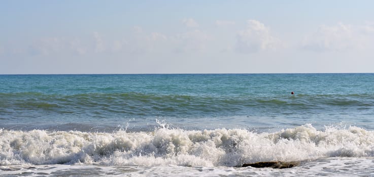 Sea wave rolled ashore. Blue sky in the background