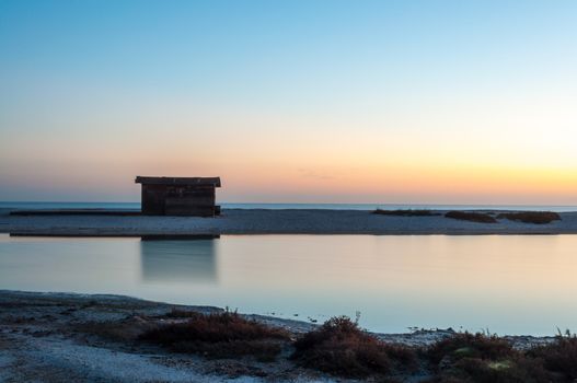 Cottage by the sea at a dawn blue, pink and orange