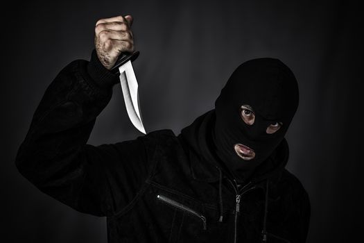 Thief in the hood on a black background 
