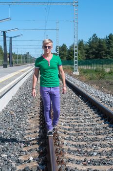 Trendy young men walking on the rail track