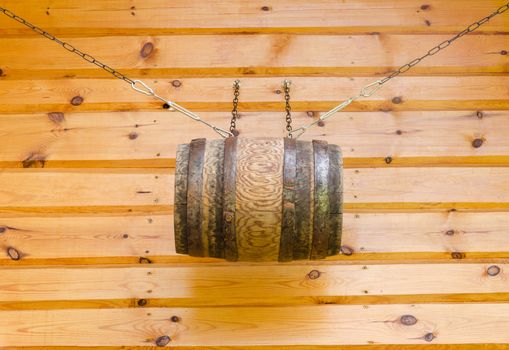 gable of the wooden rural house and decorative barrel with chains