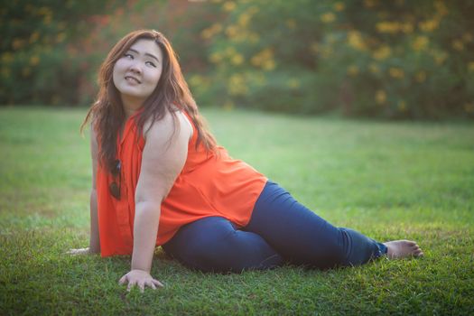 Happy fatty asian woman posing outdoor in a park