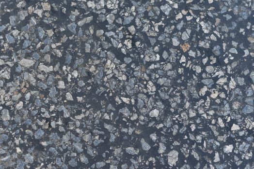 Dark asphalt surface much relief. Close up