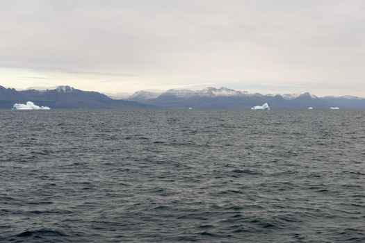 Icebergs around Disko Island in Greenland, Greenlandic seascape and landscape with mountains and water