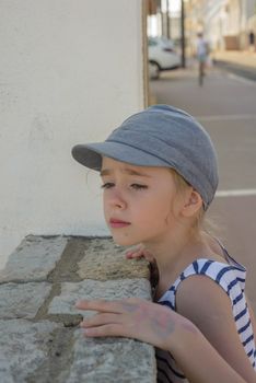 Adorable little girl in denim cap in the city