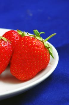 strawberries with leaves  on the plate