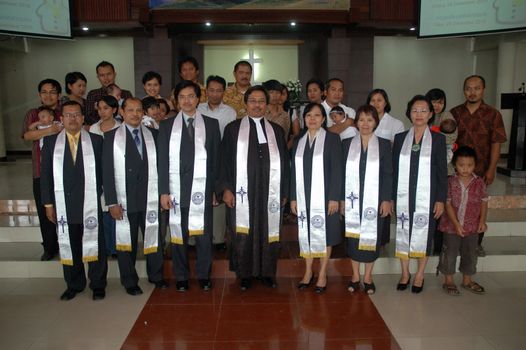 bandung, indonesia-december 19, 2010: christian priest get pictured together after baptism ceremonial.