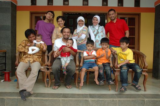 bandung, indonesia-december 19, 2010: large group of family gathering together in front of house.