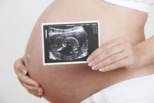 Close Up Of Pregnant Woman Holding Baby Scan