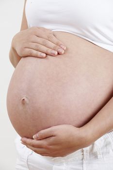 Close Up Of Pregnant Woman Holding Tummy