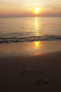 Footprints on sand beach during sun rise