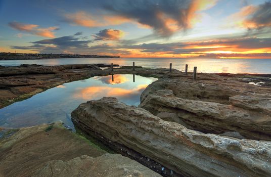 Deep channels have been eroded into the rocks by water running into this natural rock pool, South Coogee, Australia