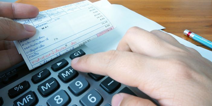 A woman using a calculator calculate the monthly payment that collected from the bill.                             