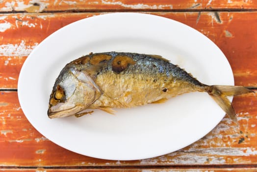Fired thai mackerel on white dish served on table