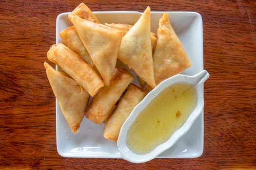 Fry Spring Roll With Sweet Sauce Serve in a White Dish on a Wood Table