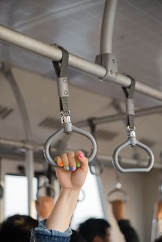 People holding onto a handle on a train