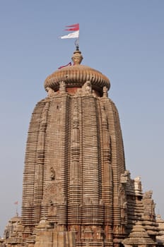 Main tower of the Lingaraja Hindu Temple. Ornately carved building with flags flying from the top. Bhubaneswar Orissa India. 11th Century AD