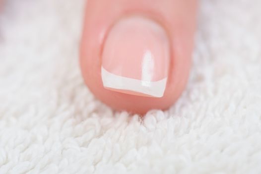 Fingers with french manicure on white towel