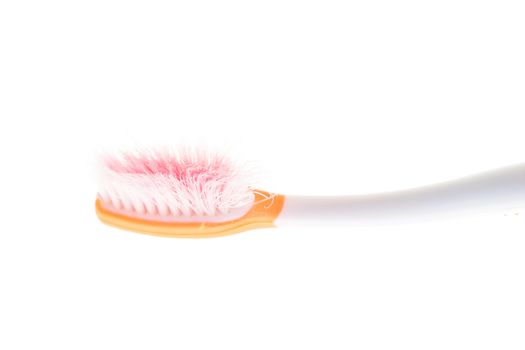 Orange worn toothbrush on white background