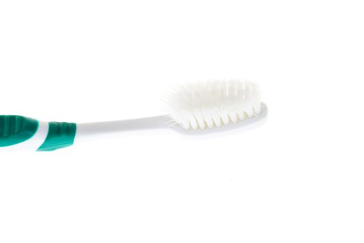 Green worn toothbrush on white background