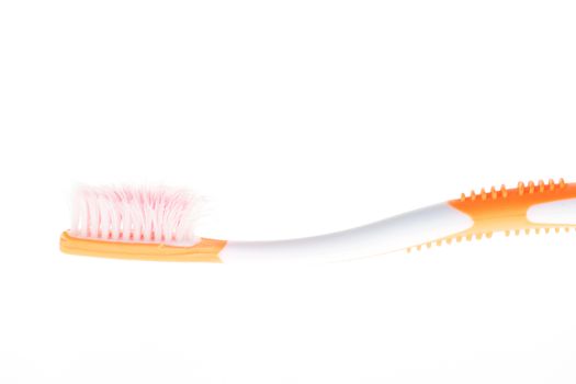 Orange worn toothbrush on white background