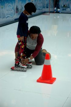bandung, indonesia-december 17, 2011: girl learning inline skate at bandung supermall venue.