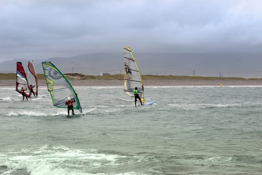 wind surfers racing in the storm winds on the wild atlantic way in county Kerry Ireland