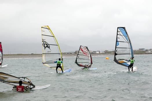 wind surfers racing in the storm winds on the wild atlantic way in county Kerry Ireland