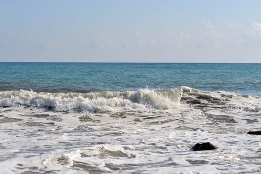 Sea wave rolled ashore. Blue sky in the background