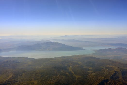 View from the plane on mountain, river and sky