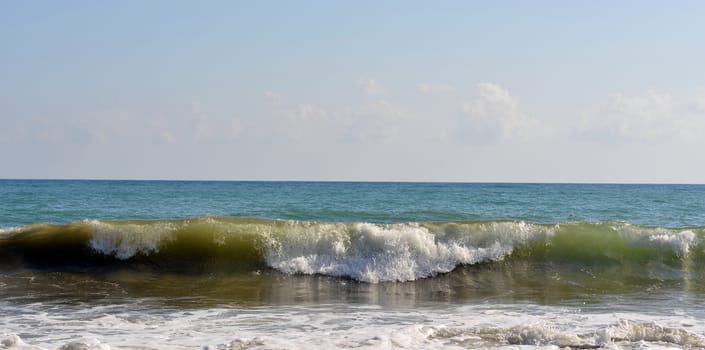 Sea wave rolled ashore. Blue sky in the background