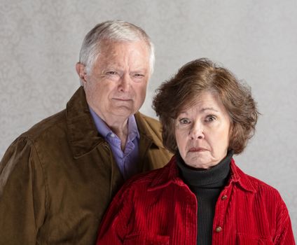 Pair of serious senior adults in jackets