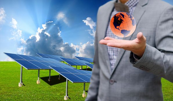 Sustainable energy concept, Solar farm with businessman carry virtual world