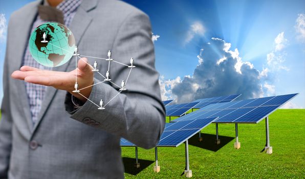 Sustainable energy concept, Solar farm with businessman carry virtual world