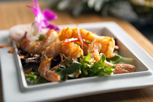 Thai shrimp dish presented on a white square dish.  Shallow depth of field.