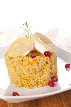 Delicious couscous with goat cheese decorated with pomegranate. Culinary vegetarian eating. 