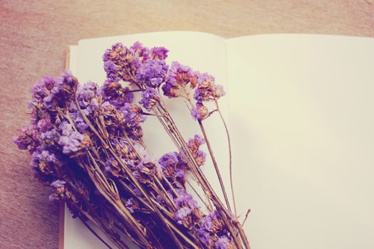 Blank notebook and dried statice flowers with retro filter effect