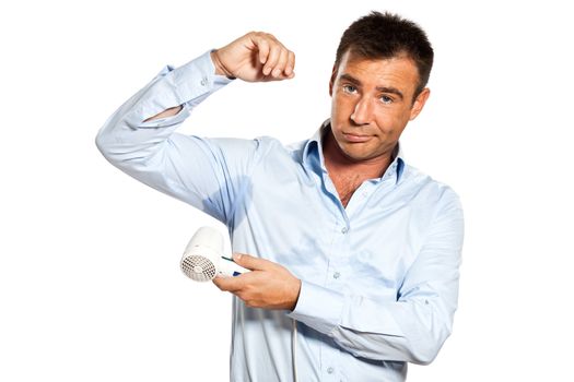 one  man with sweat stain perspire drying shirt with hair dryer in studio isolated on white background