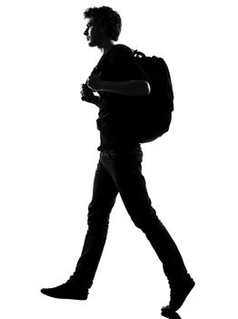 young man backpacker walking silhouette in studio isolated on white background