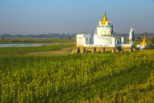 White pagoda at Ubein bridge. World longest wooden bridge. Mandalay. Myanmar