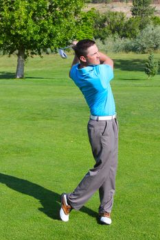 Young golfer hitting a shot with an iron 