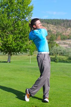 Young golfer hitting a shot with an iron 