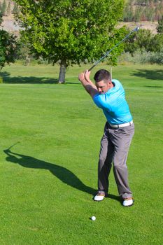 Young golfer hitting a shot with an iron 